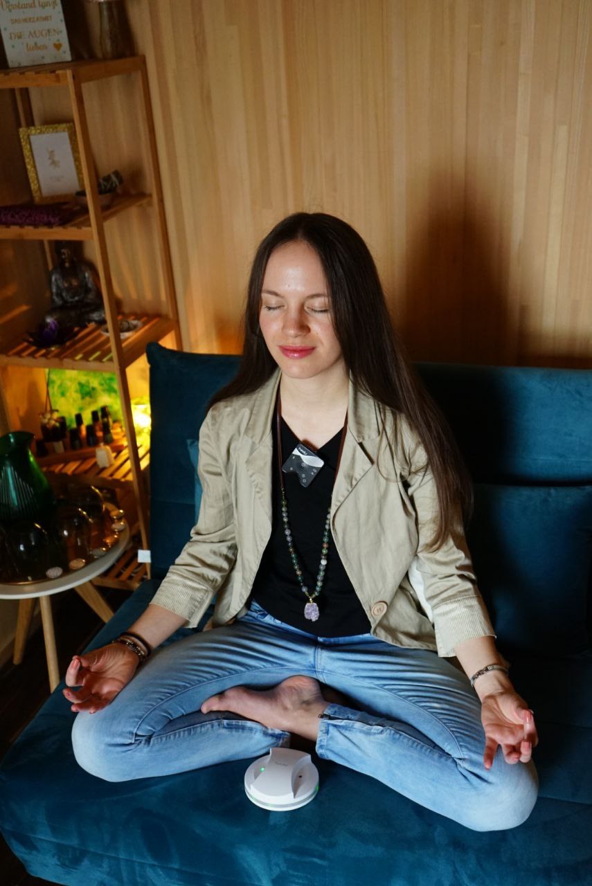 Kim sitzt mit geschlossenen Augen auf einem blauen Sofa